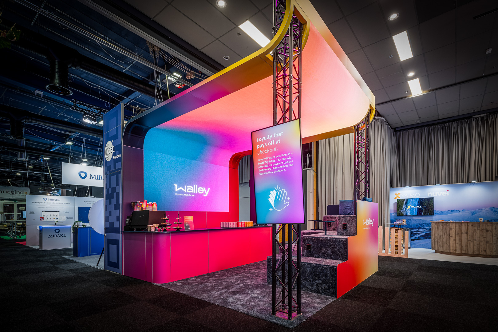 Färgstark Walley-monter med futuristisk design och information om lojalitetslösningar vid checkout.