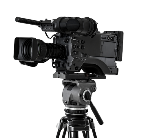 A professional video camera mounted on a tripod, positioned against a plain white background. The camera features a large lens, microphone, and multiple control buttons.